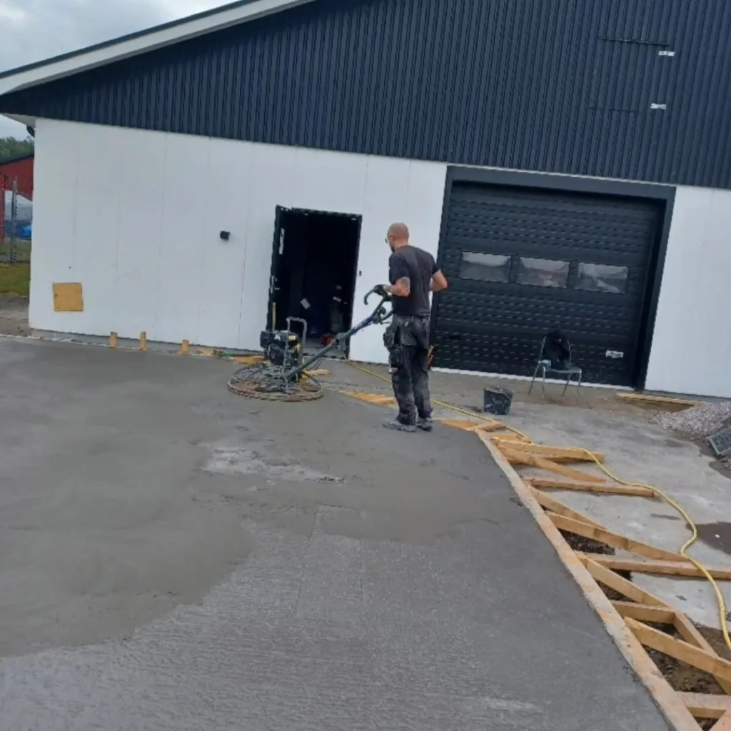 Glättning av nygjuten betongplatta vid industribyggnad