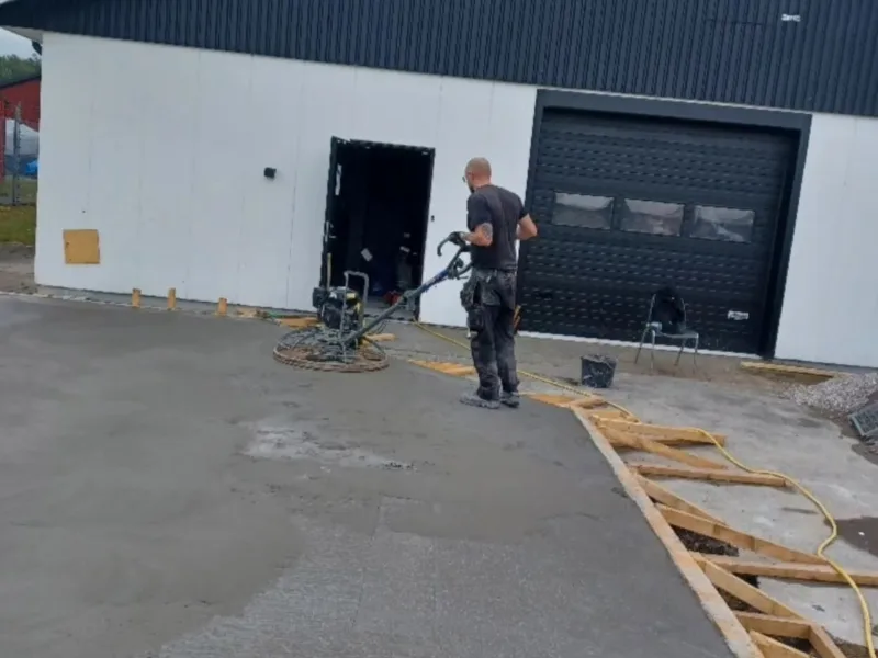 Glättning av nygjuten betongplatta vid industribyggnad