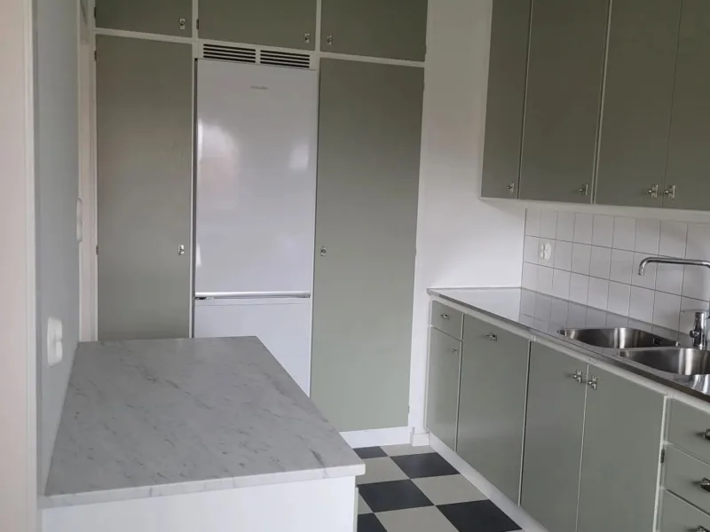 Platsbyggda köksskåp i grönt med marmorbänk